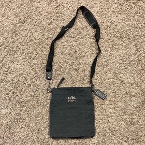 NWOT Coach crossbody black purse.  Logo emblem print.  Deep purple lining.